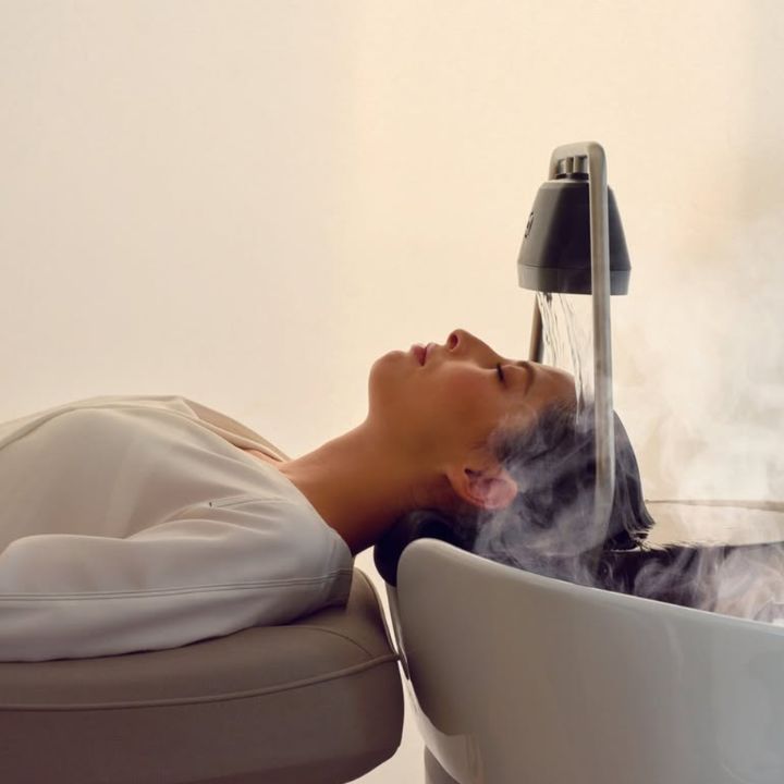 Person får en head spa-behandling vid en schamponering.